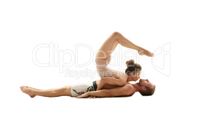 Acrobatics. Girl performs trick on man lying down