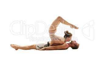 Acrobatics. Girl performs trick on man lying down