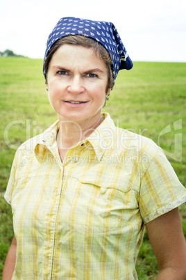 Farmer with a headscarf in the meadow