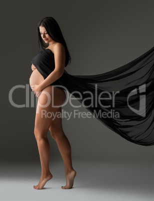 Elegant pregnant woman posing nude with cloth