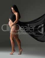 Elegant pregnant woman posing nude with cloth