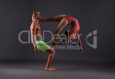 Couple of acrobats performing trick in studio