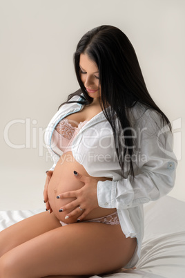 Photo of happy pregnant woman caressing her belly