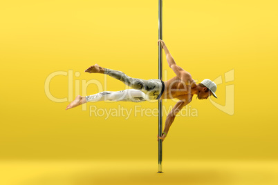 Studio photo of acrobat exercising on pole