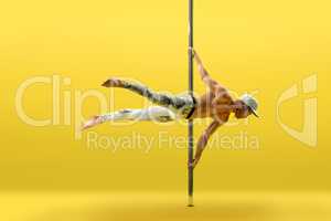 Studio photo of acrobat exercising on pole