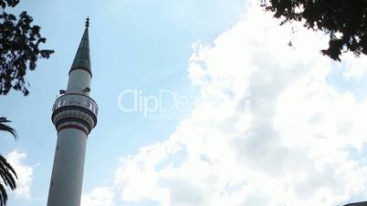 Minaret time lapse with blue sky and white clouds