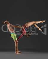 Acrobatic duo posing while practicing in studio