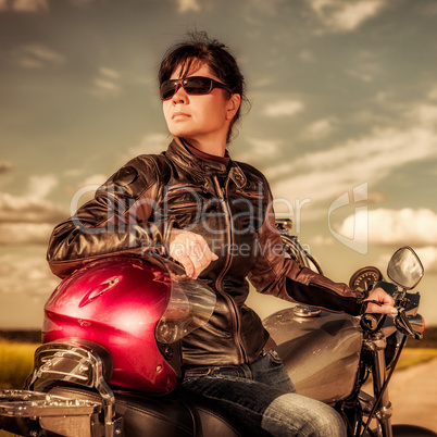 Biker girl sitting on motorcycle