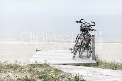 Three bicycles parked on empty beach
