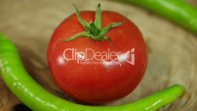 Tomato and green peppers on rotating wood.