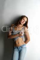 Sensual young woman posing leaning against wall