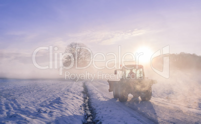 Tractor silhouette on snowy field