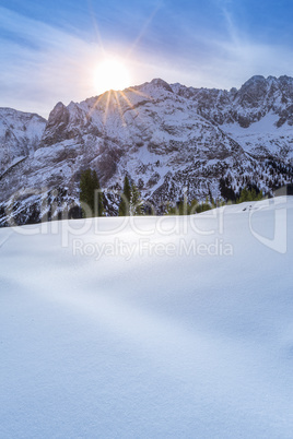 Winter sun over snowy mountain peaks
