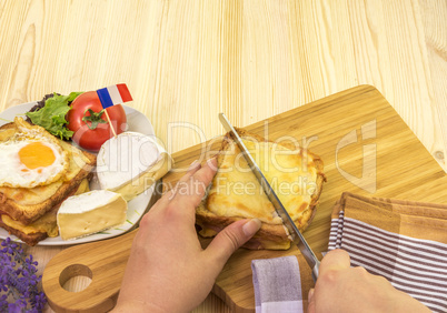 Womans hand cutting french sandwich