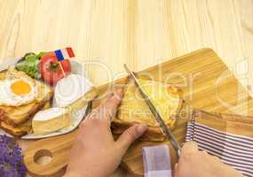 Womans hand cutting french sandwich
