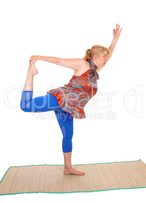 Yoga trainer standing on one leg .