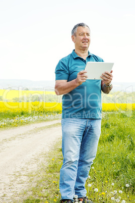 Man with tablet PC on the field