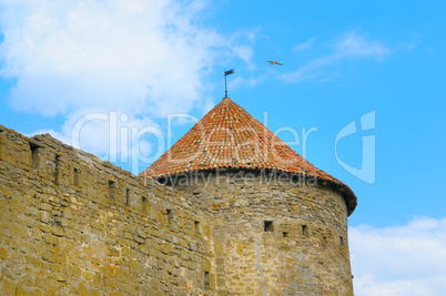 fortress tower with tiled roof on blue sky background