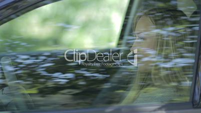Charming young woman in car fastening seat belt