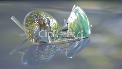 Reflection in sunglasses of woman holding car keys