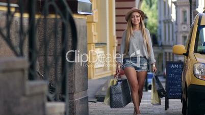 Elegant woman carrying shopping bags and smiling