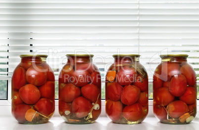 Canned tomatoes in large glass jars.