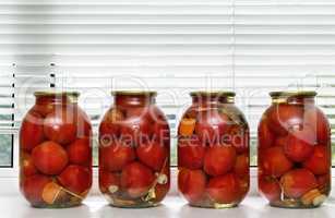 Canned tomatoes in large glass jars.