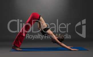 Pretty caucasian woman practising yoga in studio