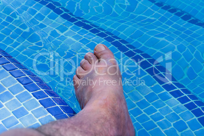 Männerfüße in einem Swimming Pool