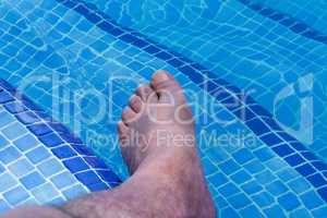 Männerfüße in einem Swimming Pool