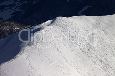 Top view on off piste slope with snowboarders and skiers at even