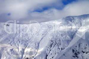 Off-piste slope at evening and sky with clouds