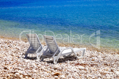 Two deck chairs on beach in sunny autumn day