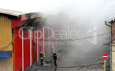 Firefighters extinguish a fire in warehouses