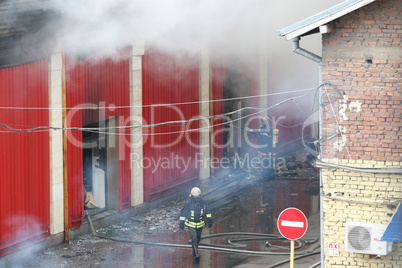 Firefighters extinguish a fire in warehouses