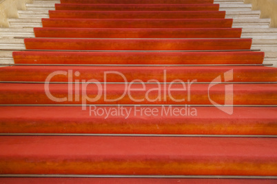 Ancient stairs with red carpet in an old building