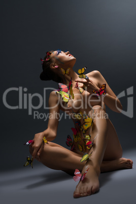 Naked model poses with body decorated butterflies