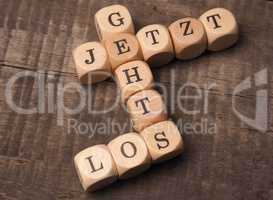 German words start now on wooden dices