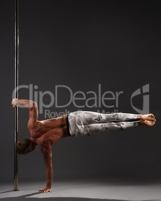 Studio photo of male athlete performing on pylon