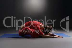 Fitness. Studio photo of girl warming up on mat