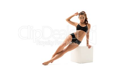 Sportswoman posing with cube, isolated on white