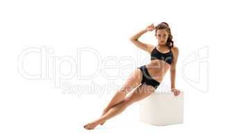Sportswoman posing with cube, isolated on white