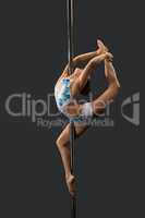 Modern dancer performing gymnastic split on pylon