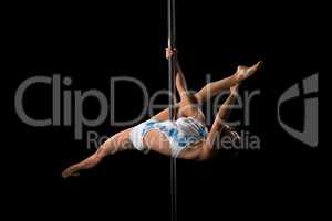 Flexible dancer performs gymnastic split on pylon