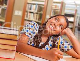 Hispanic Girl Student Daydreaming While Studying in Library