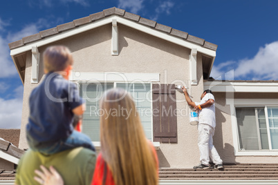 Young Family Watching House Get Painted by Painter