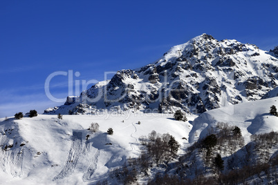 Off-piste slope with track from avalanche on sunny day