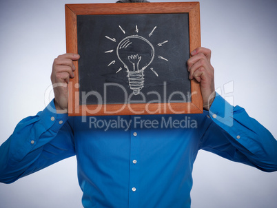 Businessman holding a small chalkboard with a lightbulb on it