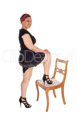Woman standing leg on chair.