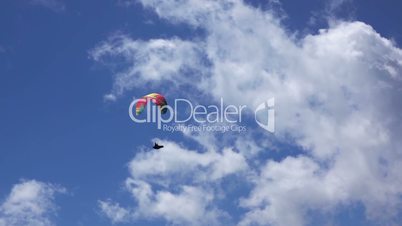 Paraglider on Blue Sky Background and Clouds